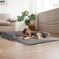 Dog lying on a gray pet bed in a modern living room.