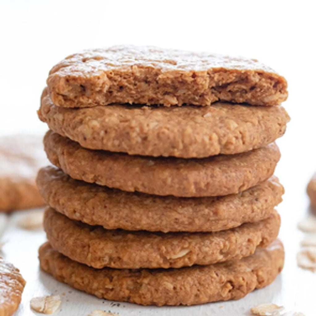 Stack of oatmeal cookies on a white surface with blurred background