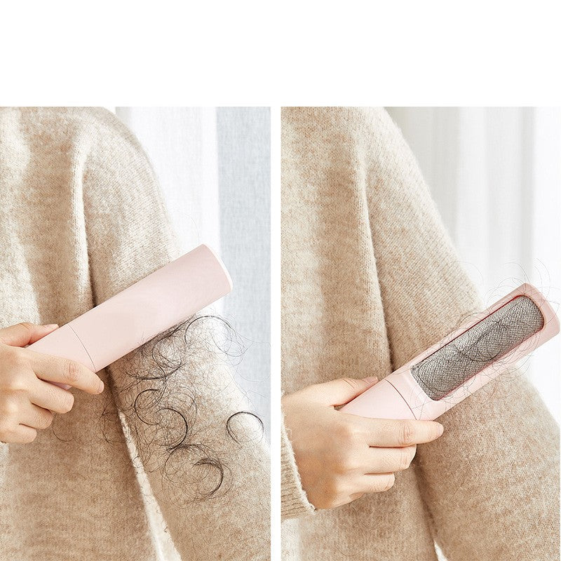 Person using a pink pet hair remover on a beige sweater with hair being removed.