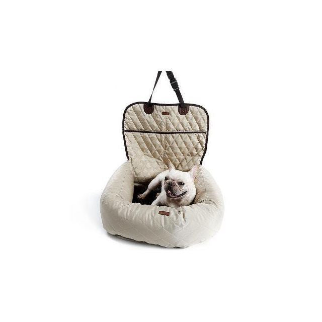 Dog sitting in a beige pet carrier on a white background