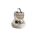 Dog sitting in a beige pet carrier on a white background