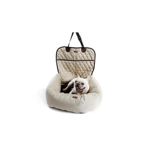 Dog sitting in a beige pet carrier on a white background
