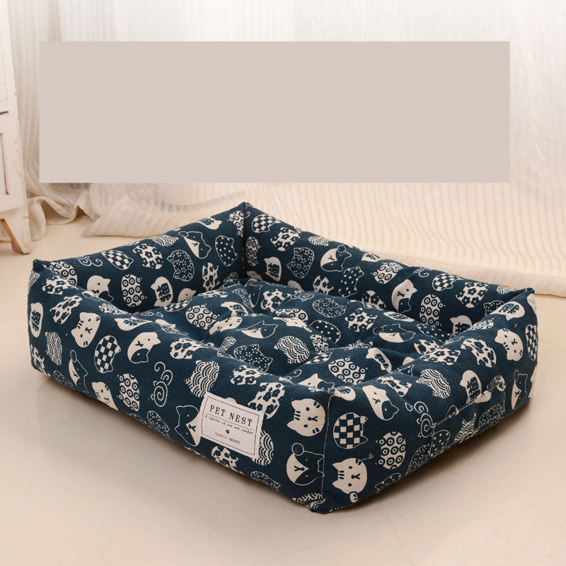 Blue pet bed with white patterns on a light-colored floor.