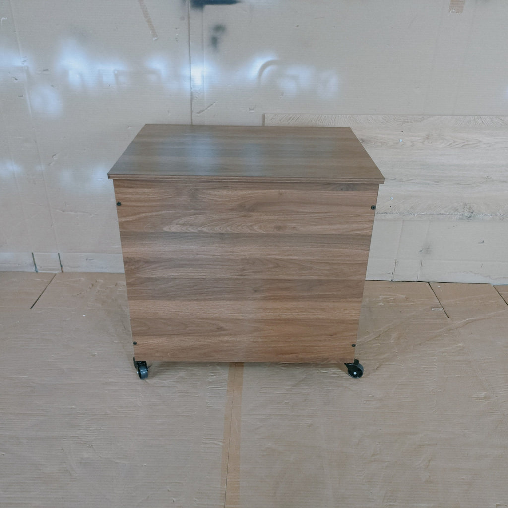 Wooden storage unit with wheels on a plain floor.