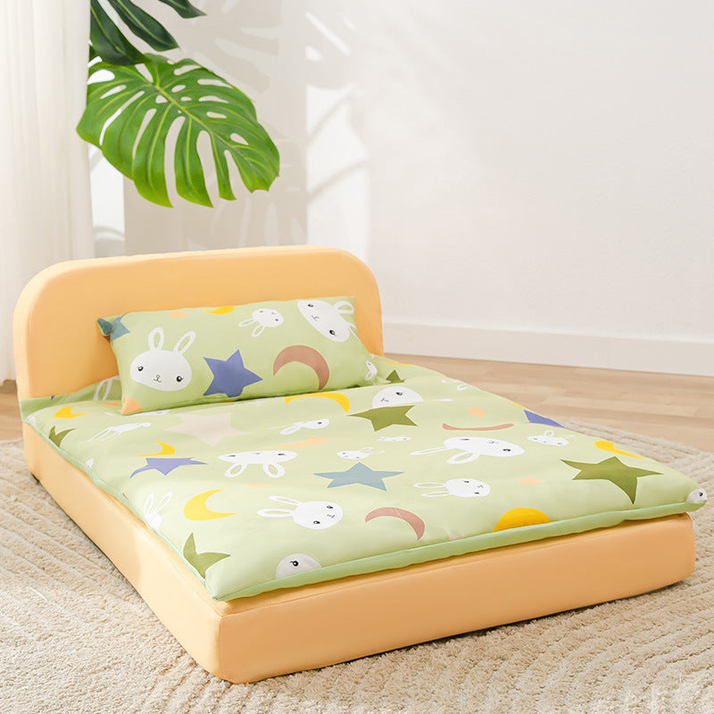 dog bed with cartoon-patterned mattress and yellow frame in a room with a plant.