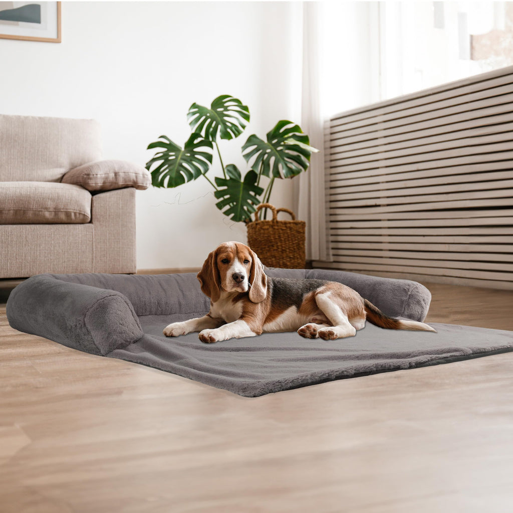 Dog lying on a gray pet bed in a modern living room.