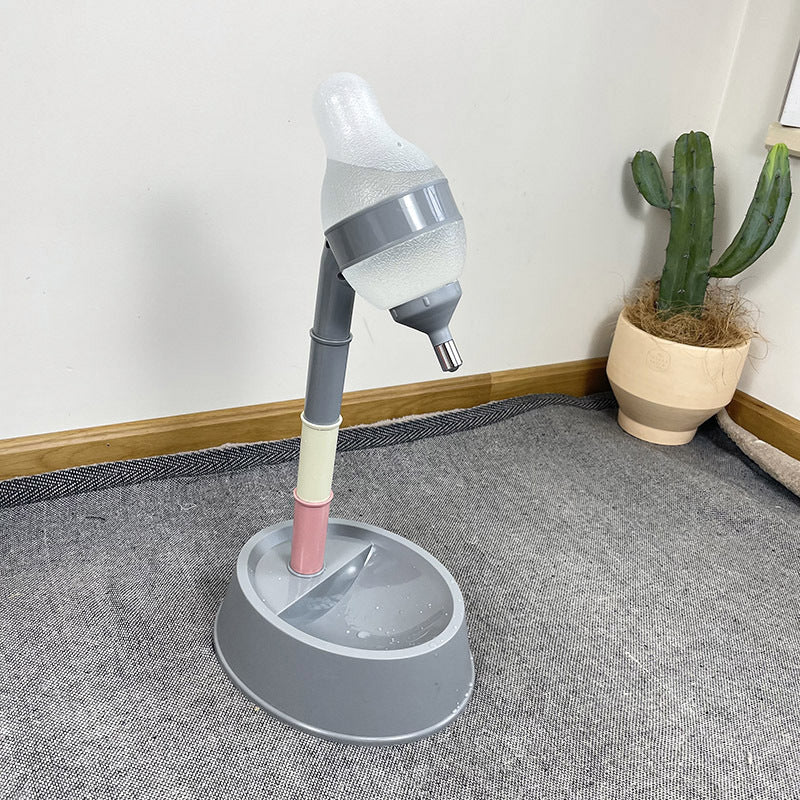 Gray pet water fountain on a carpeted floor with a cactus plant in the background.