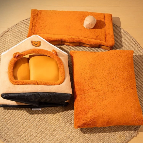Orange pet bed and house on a textured surface