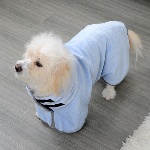 Small dog wearing a light blue hoodie on a gray floor.