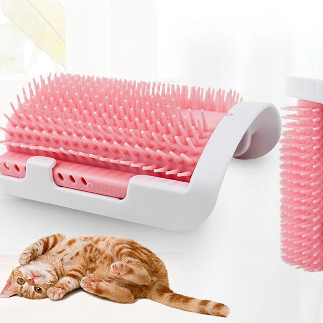 Pink and white pet grooming brush with a cat lying next to it on a light background