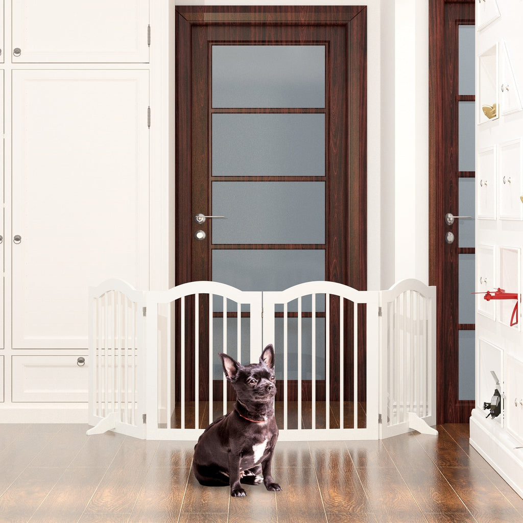 Dog sitting behind a white baby gate in a home setting