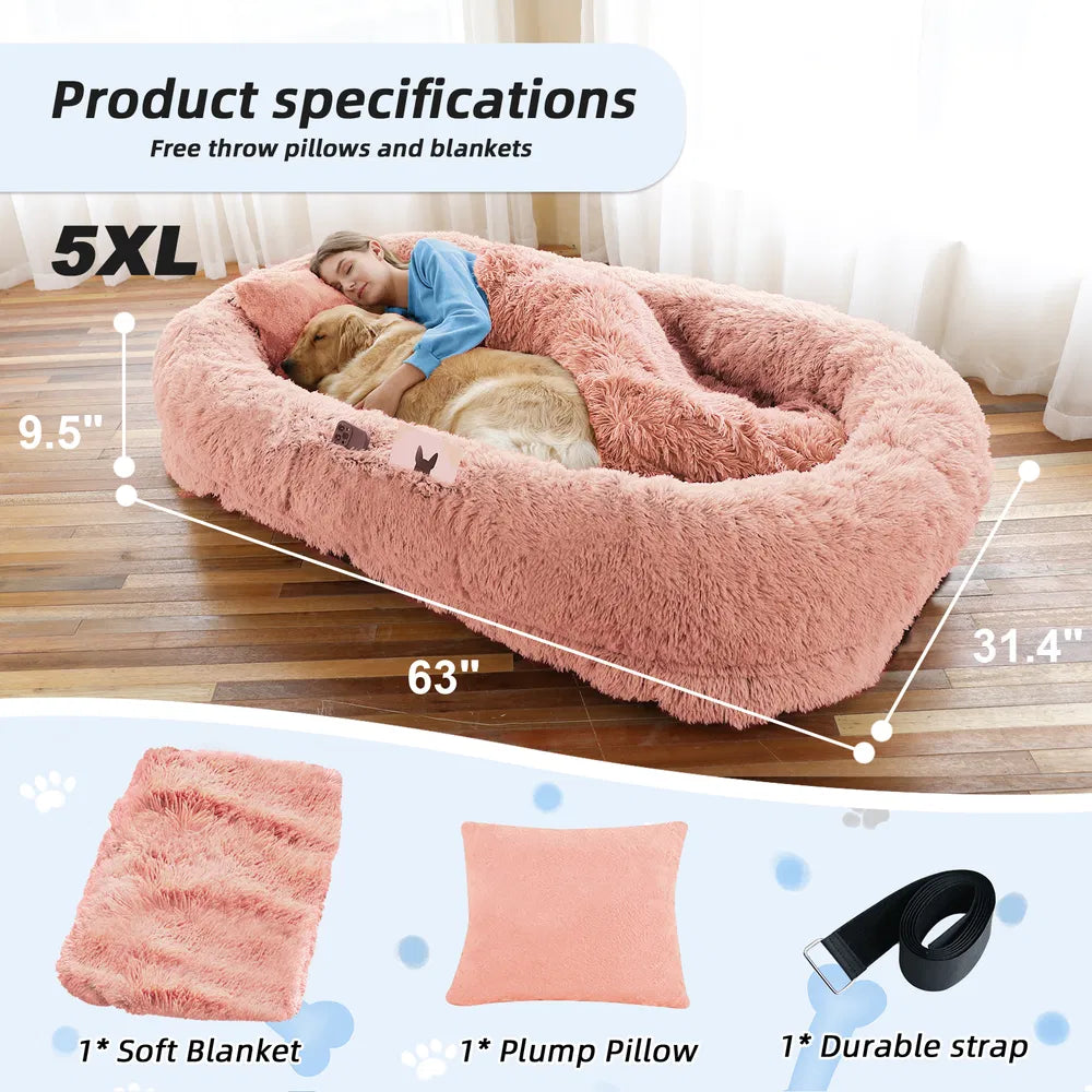 Large pink pet bed with measurements and included items on a wooden floor.