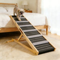 Dog using a pet ramp to climb onto a bed in a bedroom setting