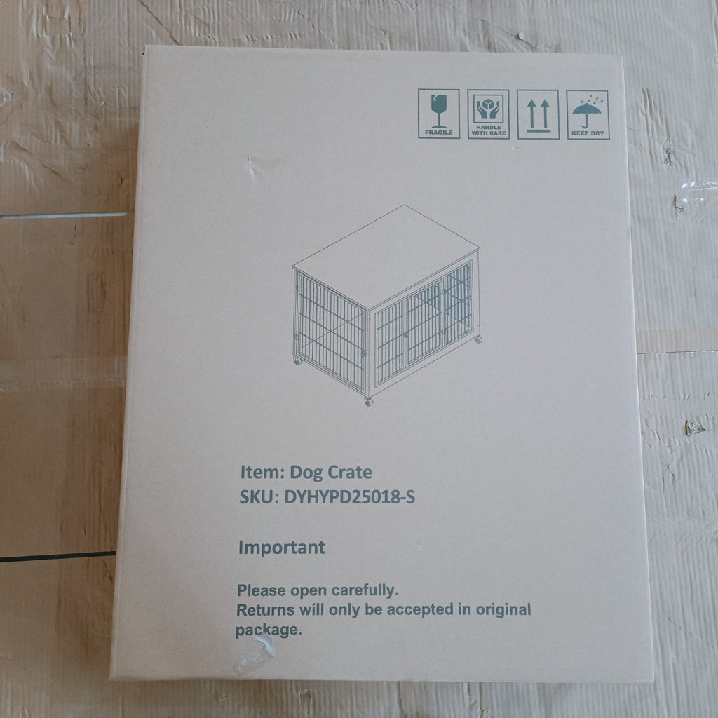 Cardboard box with a dog crate illustration and text on a wooden floor.