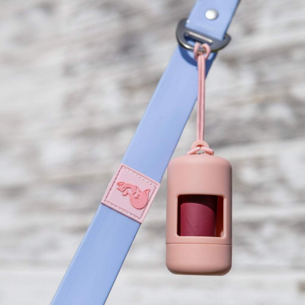 Dog leash with a pink plastic bag holder attached, featuring a brand logo.