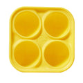 Yellow silicone mold with four circular compartments on a white background