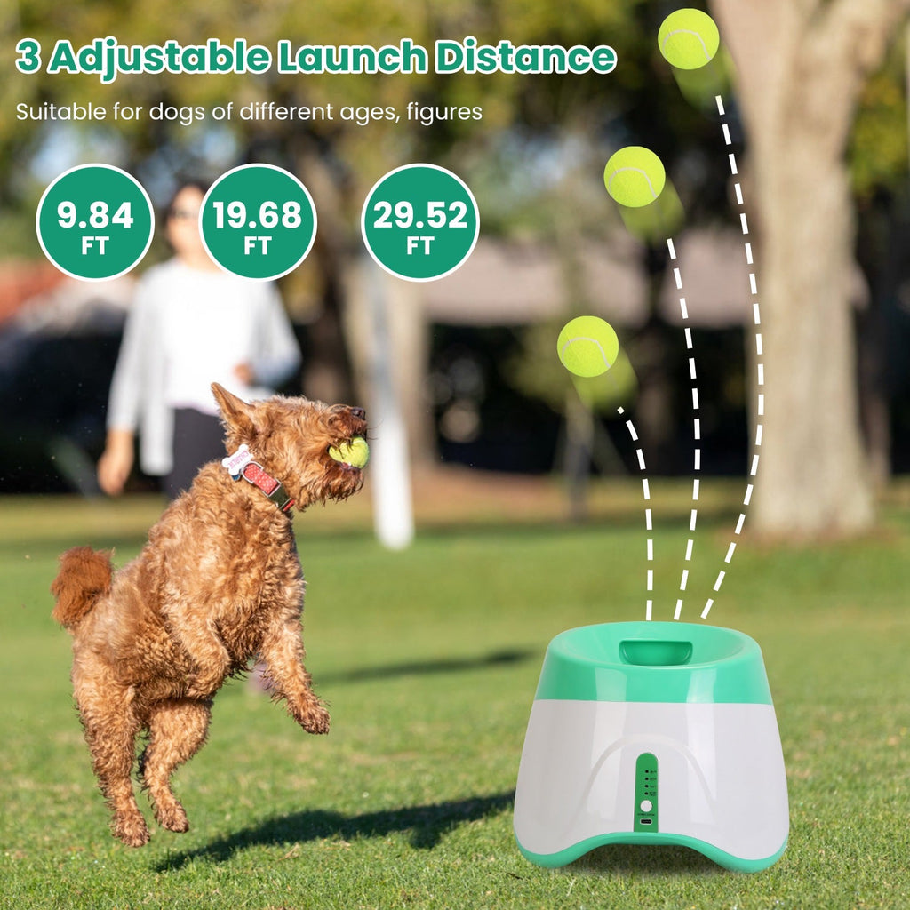 Dog playing with a ball launch device on grass, with adjustable launch distance indicators.