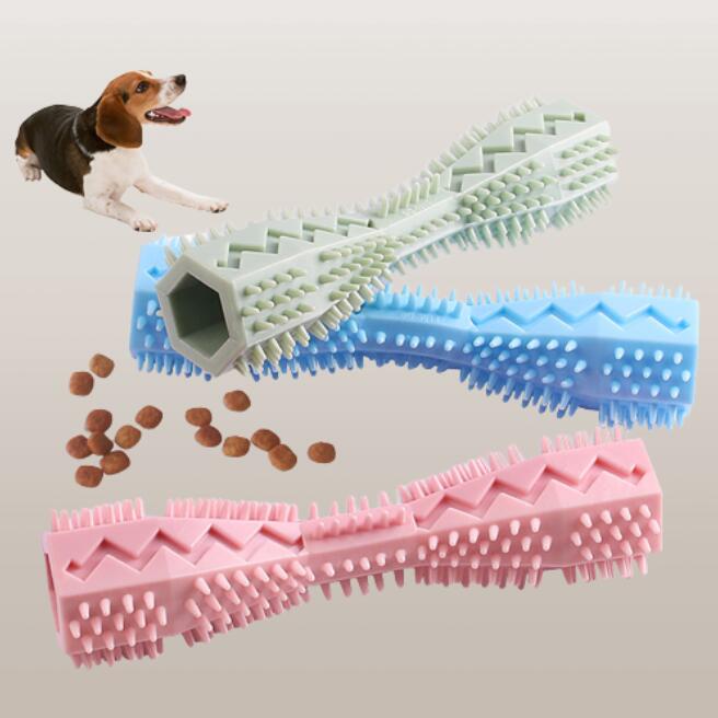 Three dog chew toys in blue, green, and pink on a light gray background with a small dog and scattered treats.