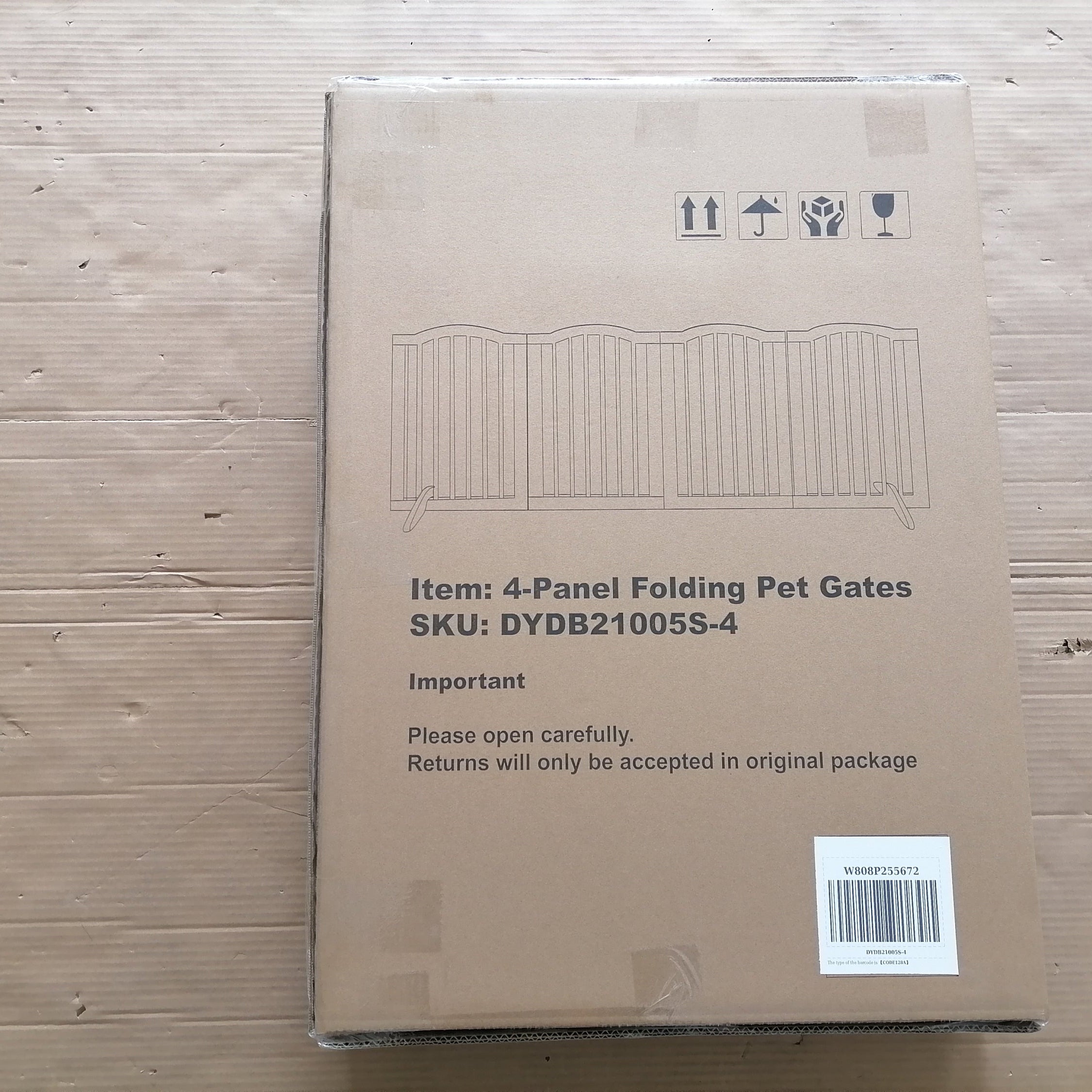 Cardboard box with pet gate packaging on a wooden surface