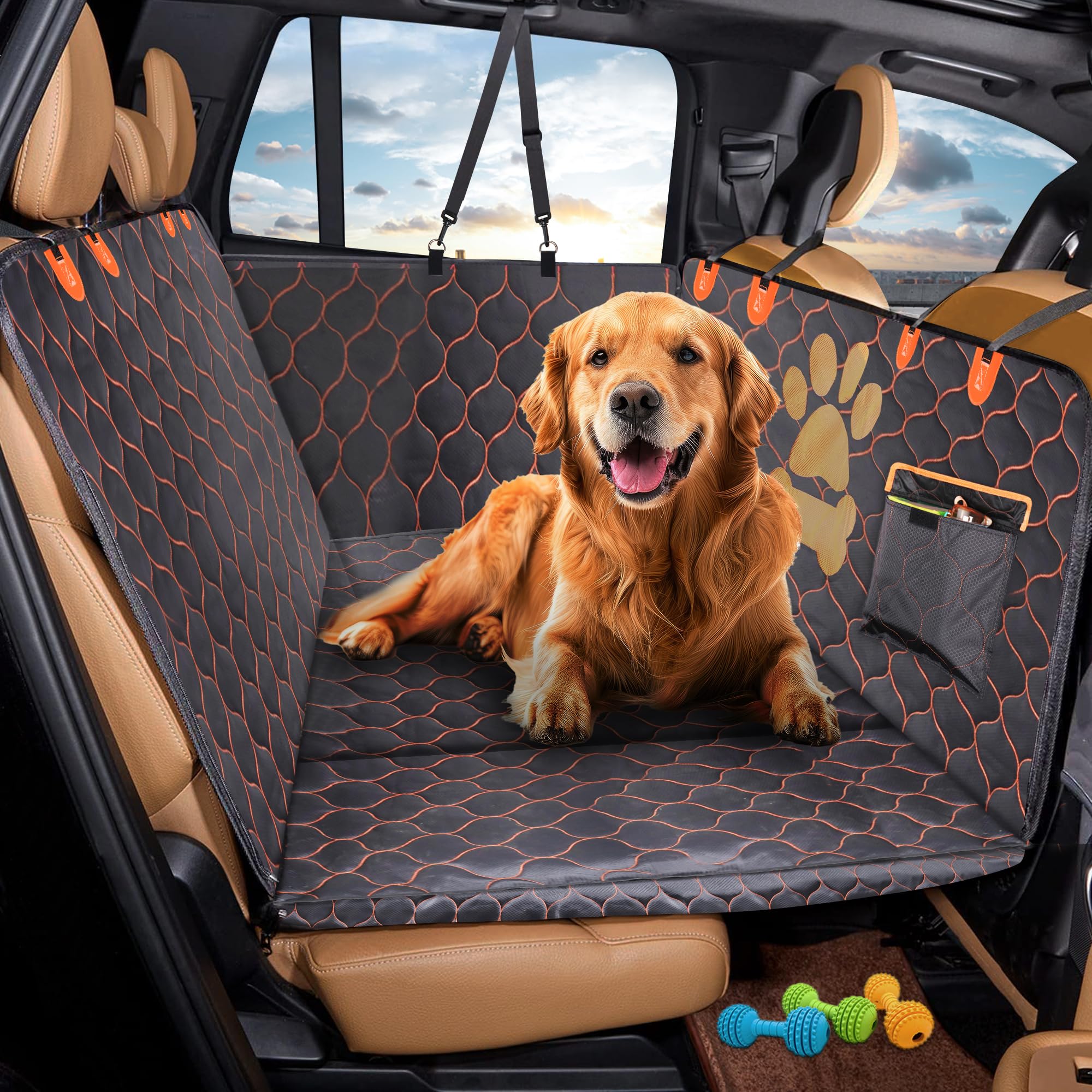 Dog sitting on a car seat cover with a paw print design, inside a vehicle.