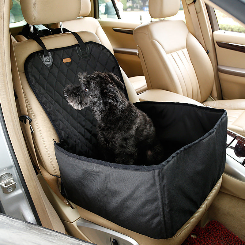 Dog sitting inside a black car seat cover in a vehicle.
