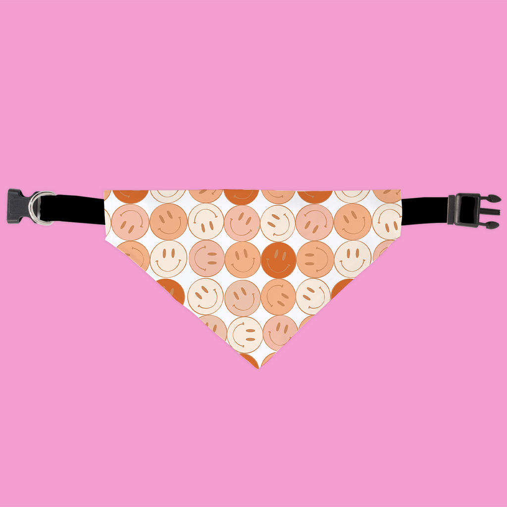 Dog bandana with smiley face pattern on a pink background