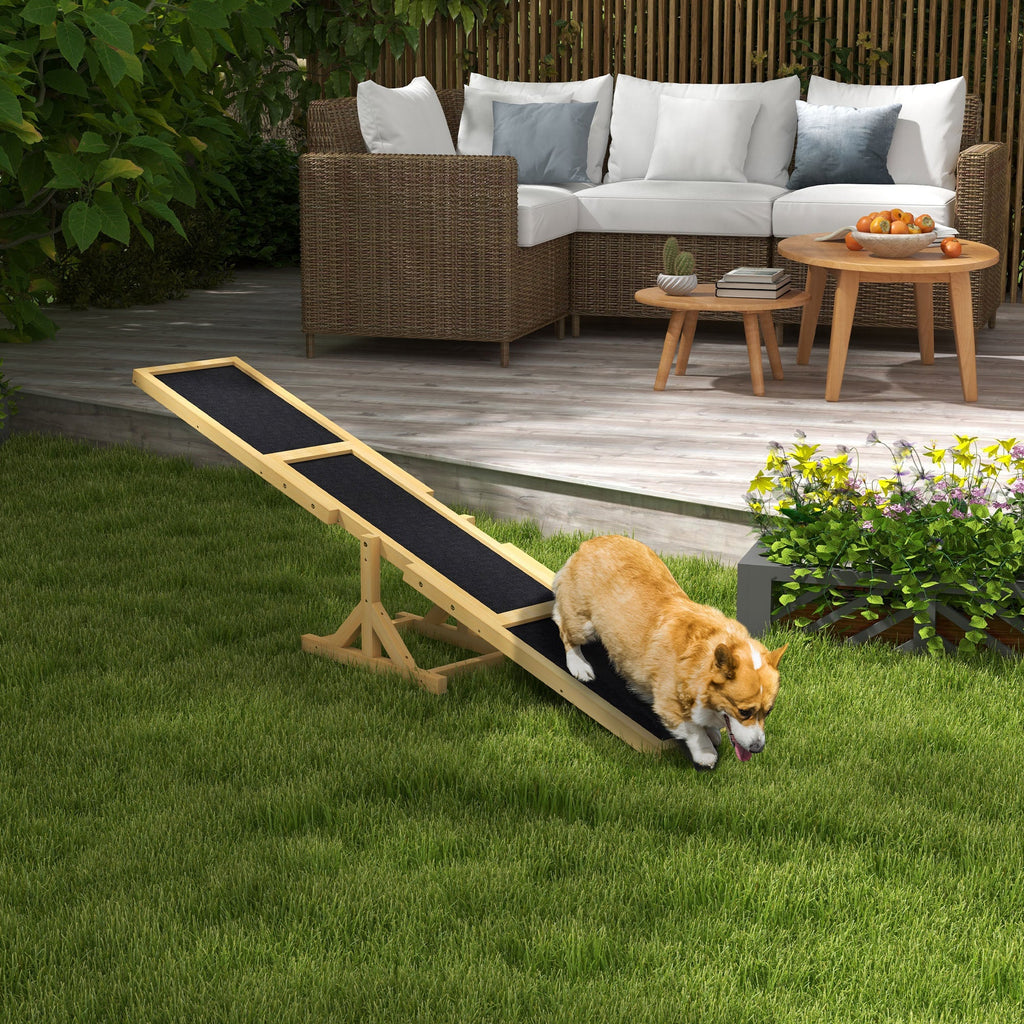 Dog using a wooden ramp in a backyard with outdoor furniture and plants.