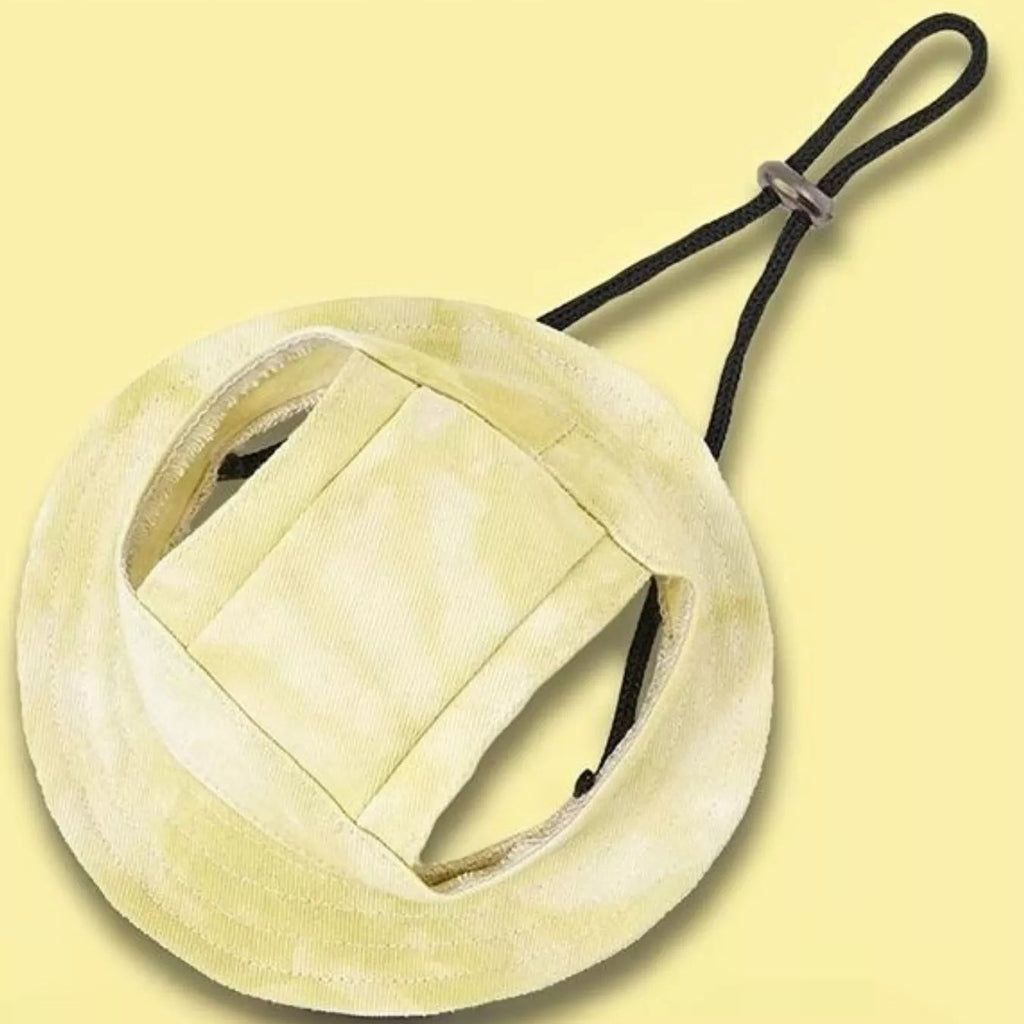 Round beige object with a black strap on a light yellow background