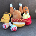 Plush toys shaped like a hot dog, bun, and fries on a gray surface.