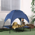 Dog lying on a blue pet cot with canopy in a room.