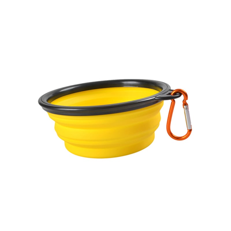 Yellow collapsible dog bowl with black rim and orange carabiner on a white background