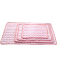 Set of three pink quilted mats on a white background