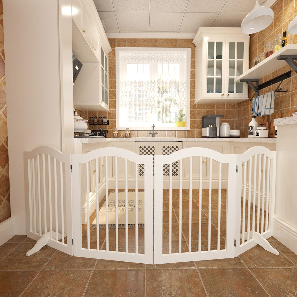 White pet gate in a kitchen setting with tiled floor and cabinets.