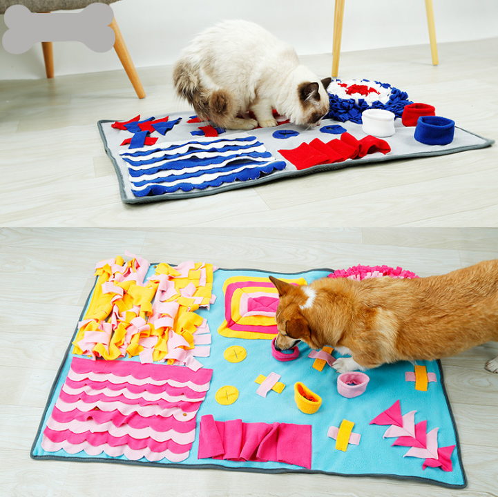 Two cats playing with a colorful interactive mat on a wooden floor.