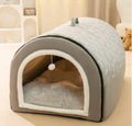 Pet bed with a soft interior and patterned exterior on a beige surface.