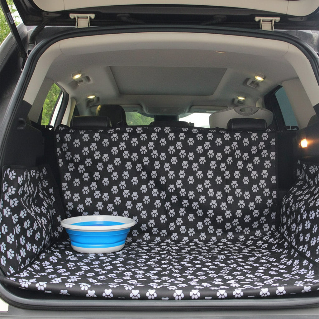 Car trunk with a black and white paw print cover and a blue bowl inside.