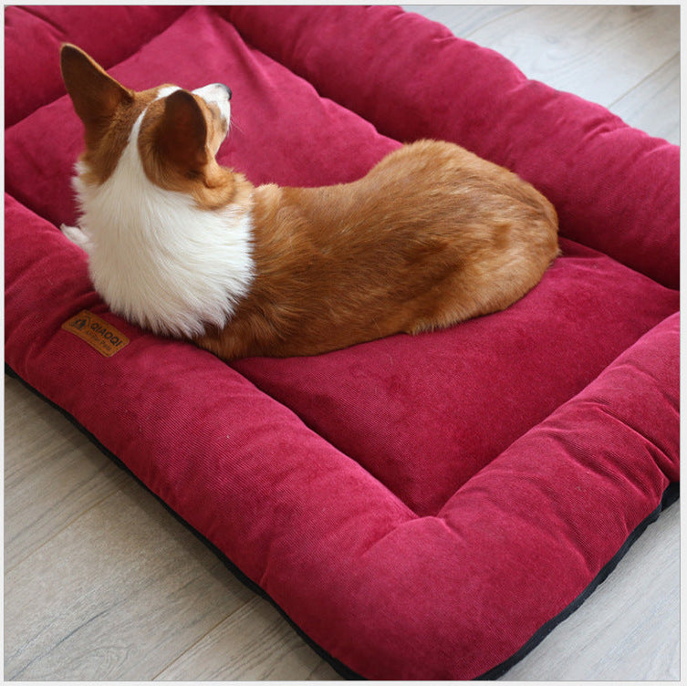 Dog lying on a red pet bed with a visible brand label.
