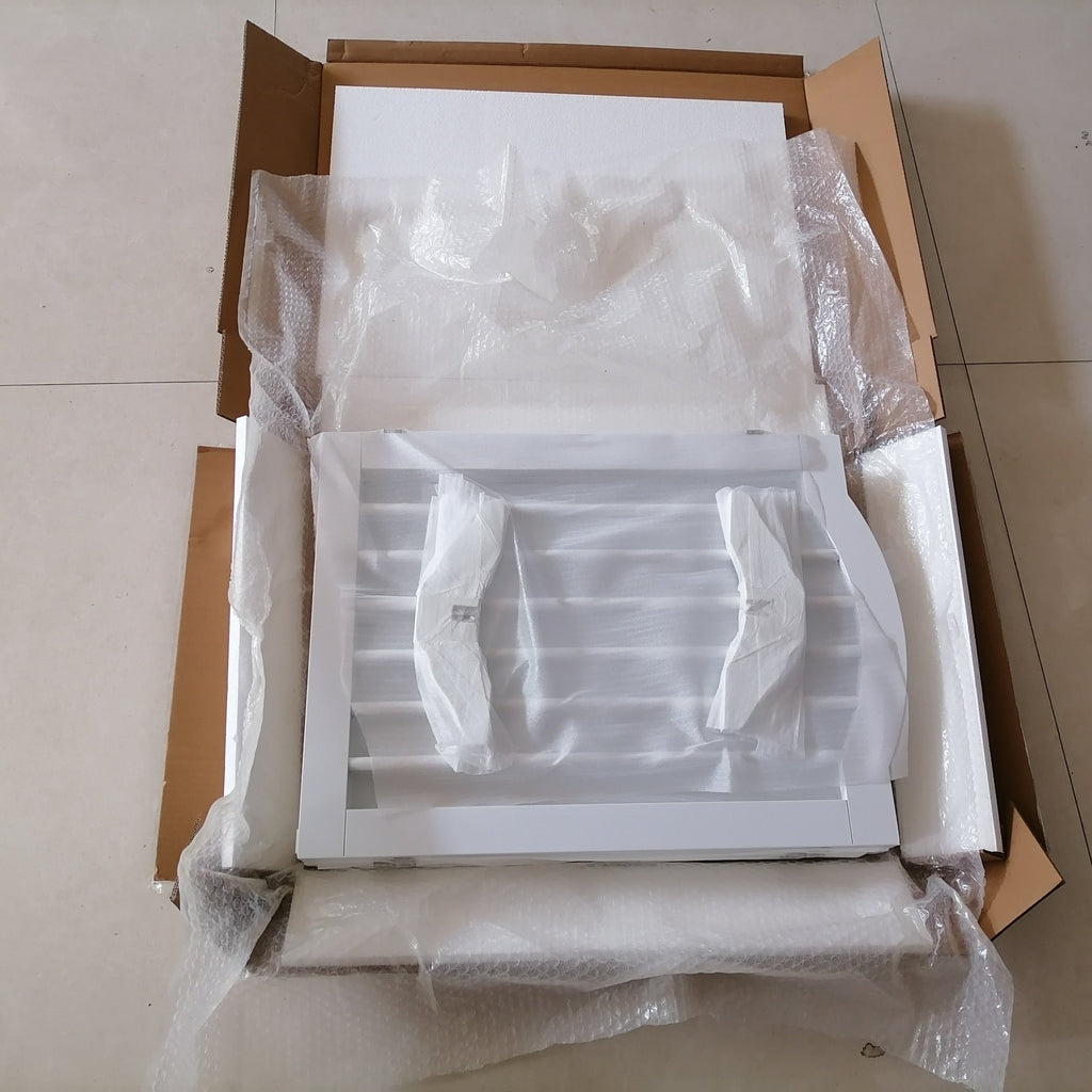 Unpacked white plastic drawer in a cardboard box on a tiled floor